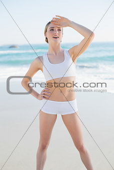 Happy slender woman standing hands on hips looking away