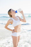 Peaceful slender woman drinking from sports bottle