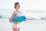 Lovely young woman holding an exercise mat