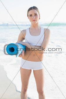 Serious brunette woman standing on the beach