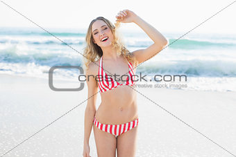 Amused blonde woman posing on the beach