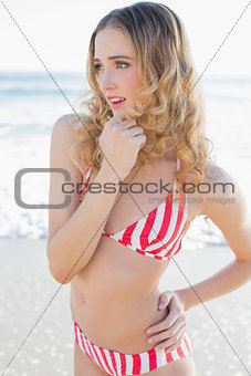 Attractive woman posing on beach wearing a red bikini