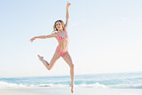 Lovely young woman jumping on the beach
