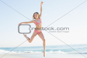 Lovely young woman jumping on the beach
