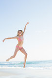 Beautiful blonde woman jumping on the beach