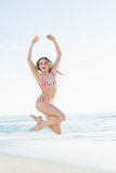 Content young woman jumping on the beach