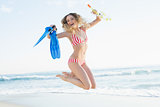 Cheerful woman jumping on beach