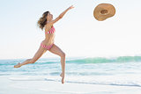 Joyful young woman jumping on beach