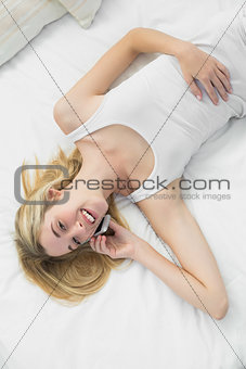 Cute calm woman phoning with her smartphone smiling at camera