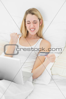 Content successful woman using laptop for home shopping