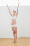 Toned woman stretching standing in sports hall