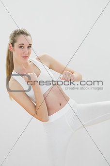 Pretty toned woman wearing sportswear pracitsing martial arts