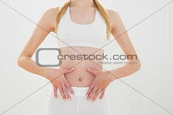 Sporty woman wearing sportswear touching her belly