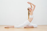 Beautiful fit woman in sportswear doing yoga pose in sports hall