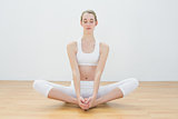 Calm woman practising yoga sitting in lotus position on floor