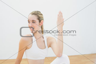 Gorgeous sporty woman doing yoga pose sitting on floor