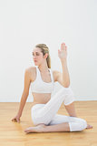 Focused toned woman stretching her body sitting on floor