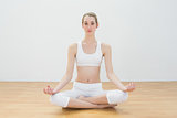 Focused calm woman meditating sitting in sports hall