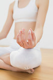 Close up of slender young woman meditating sitting in lotus position