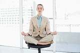 Attractive classy woman sitting in lotus position on her swivel chair