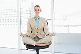 Content classy businesswoman sitting in lotus position on her swivel chair