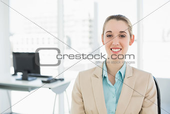 Happy classy woman sitting smiling on her swivel chair