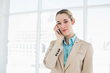 Pretty chic businesswoman phoning with her smartphone