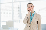 Cute smiling chic businesswoman phoning with her smartphone