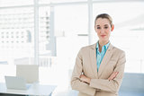 Chic businesswoman posing confidently with arms crossed