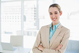 Lovely smiling chic businesswoman posing with arms crossed smiling at camera