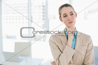 Cute thoughtful chic businesswoman standing in her office
