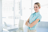 Beautiful young businesswoman posing with arms crossed in her office