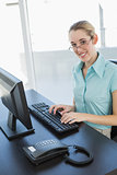 Content calm businesswoman sitting at her desk working on computer