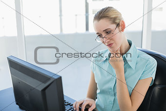 Concentrated chic businesswoman using her computer
