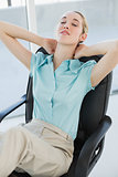 Tired chic businesswoman relaxing sitting on her swivel chair