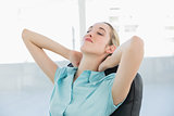 Beautiful peaceful businesswoman relaxing on her swivel chair
