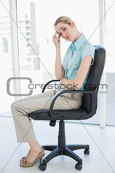 Exhausted classy businesswoman sitting on her swivel chair