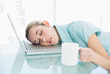 Young exhausted businesswoman sleeping sitting on her swivel chair