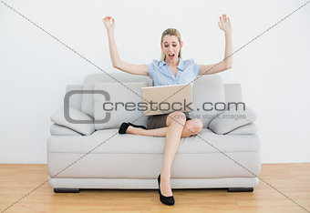 Extremely cheering chic businesswoman sitting on her couch