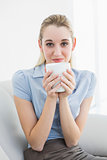 Gorgeous calm businesswoman holding a cup smelling a cup