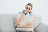 Content peaceful businesswoman sitting on couch holding a pillow