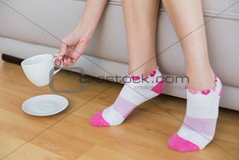 Young woman wearing pink socks holding a cup