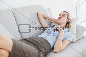 Tired chic businesswoman sleeping lying on couch