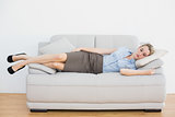 Peaceful blonde chic businesswoman lying sleeping on couch