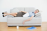 Exhausted young businesswoman sleeping lying on her couch