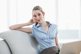 Smart businesswoman sitting on couch holding her notebook