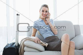 Gorgeous calm businesswoman phoning while sitting on couch