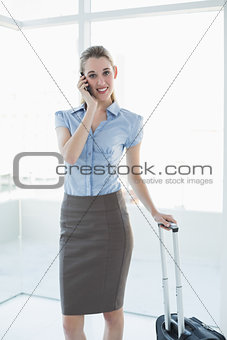 Gorgeous peaceful businesswoman phoning while standing in her office