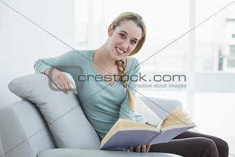 Content peaceful woman relaxing reading a book sitting on couch