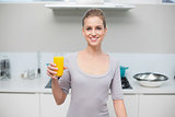 Cheerful gorgeous model looking at camera holding orange juice